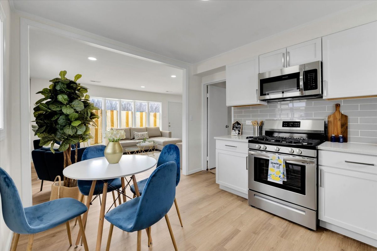 192 Monee Road Park Forest, IL 60466 - Photo 9 of 25 a kitchen with stainless steel appliances a dining table and chairs