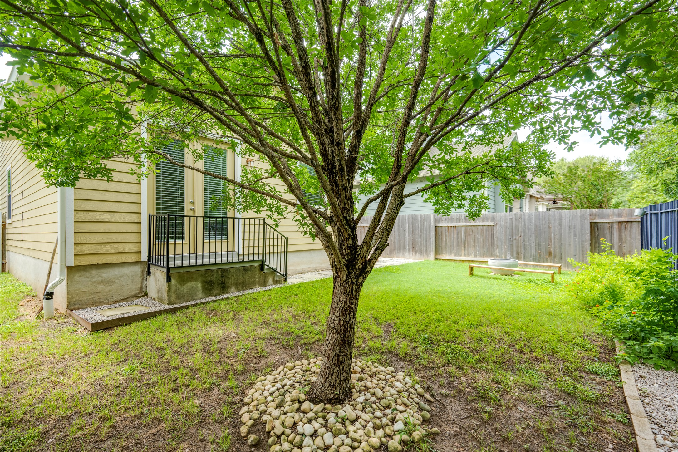 6008 Whipple Way Austin, TX 78745 - Photo 37 of 39 A private backyard oasis awaits, featuring a mature tree, vibrant green lawn, and secluded patio.