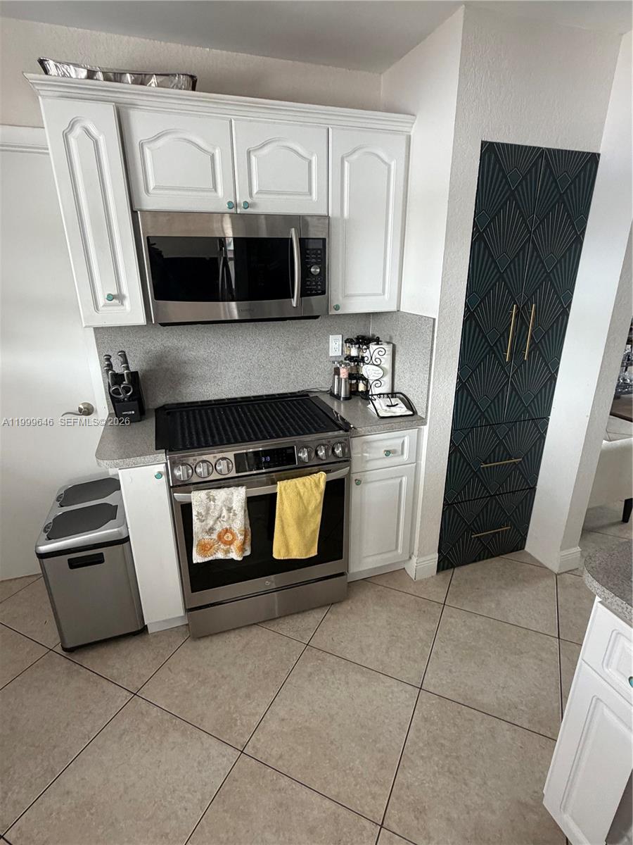 13267 Southwest 9th Lane Miami, FL 33184 - Photo 11 of 53 a kitchen with granite countertop a stove and a microwave