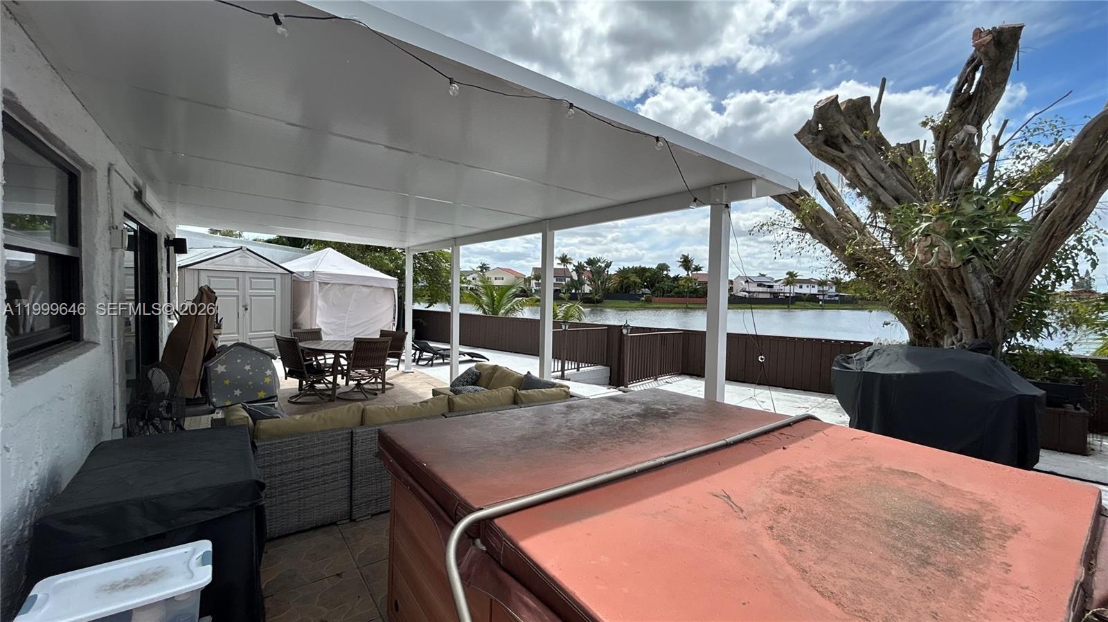 13267 Southwest 9th Lane Miami, FL 33184 - Photo 44 of 53 a view of a patio with table and chairs a barbeque with wooden fence and roof