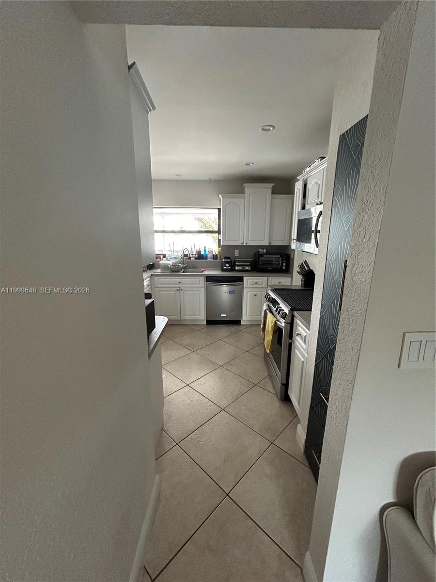 13267 Southwest 9th Lane Miami, FL 33184 - Photo 8 of 53 a kitchen with granite countertop a refrigerator stove and sink