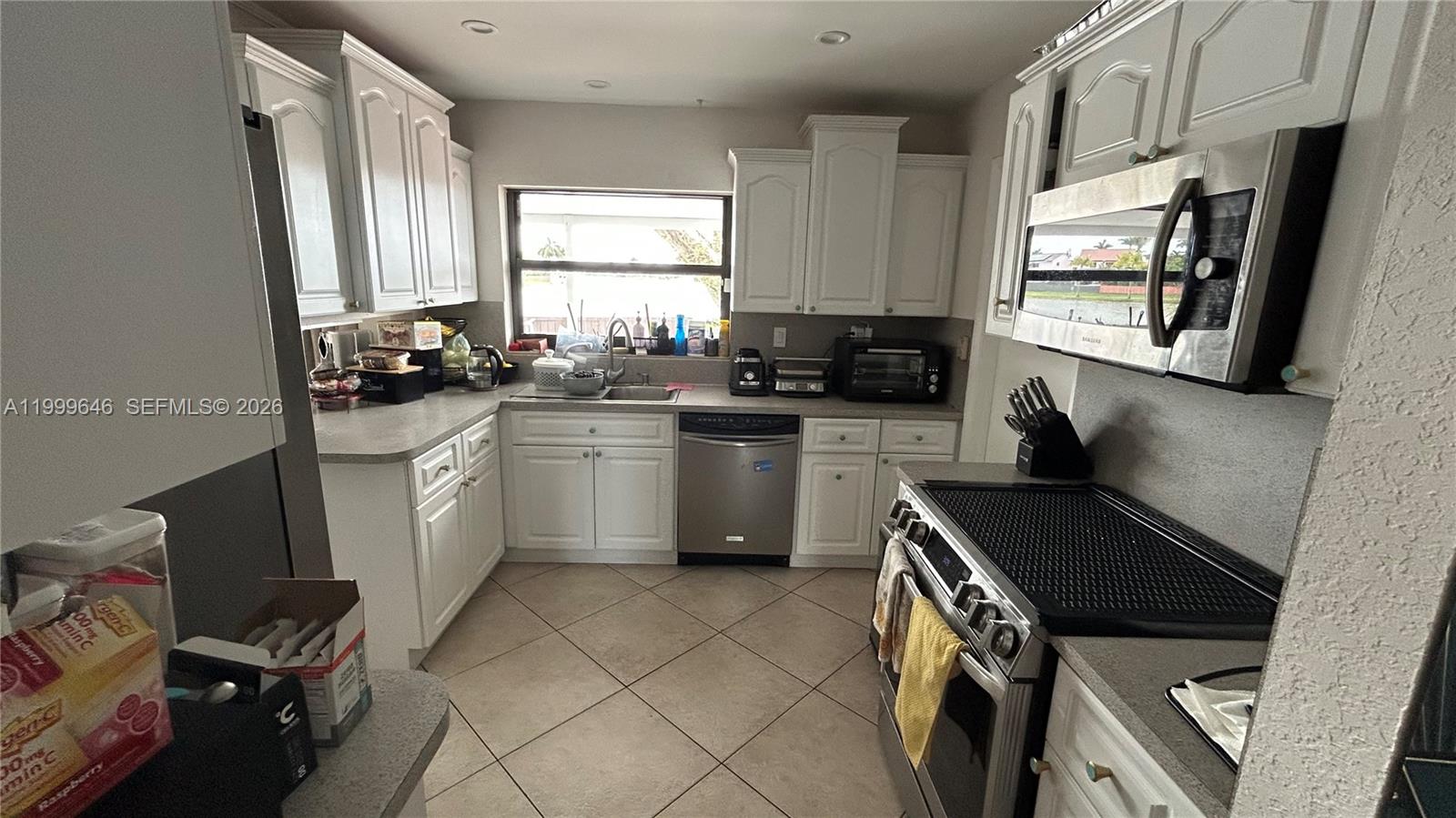 13267 Southwest 9th Lane Miami, FL 33184 - Photo 9 of 53 a kitchen with a sink appliances cabinets and a window
