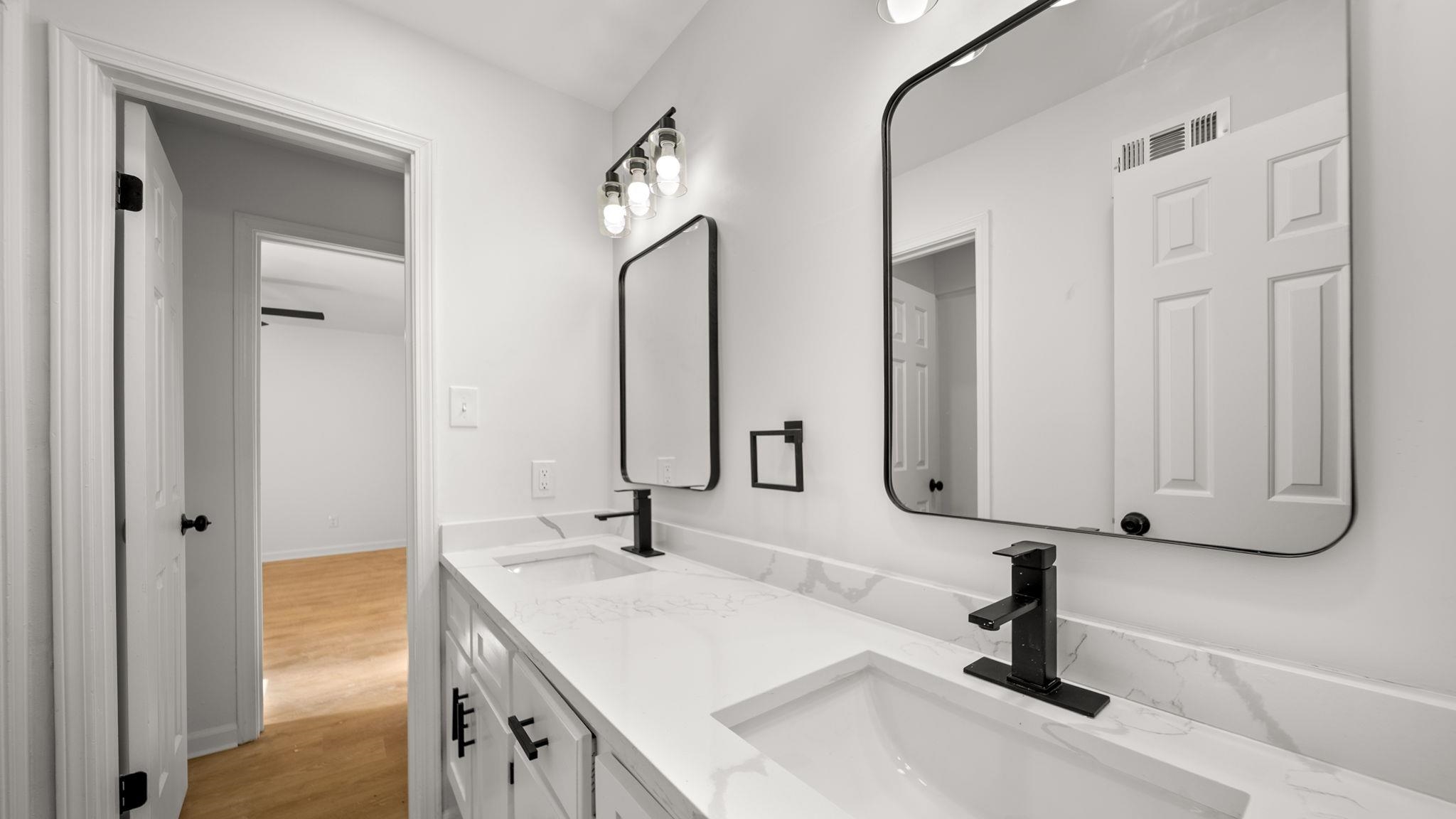 4351 Spring Oak Cove Memphis, TN 38125 - Photo 27 of 40 a bathroom with double vanity sinks and a mirror