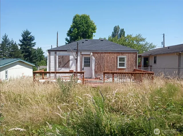 a front view of house with yard and trees in the background