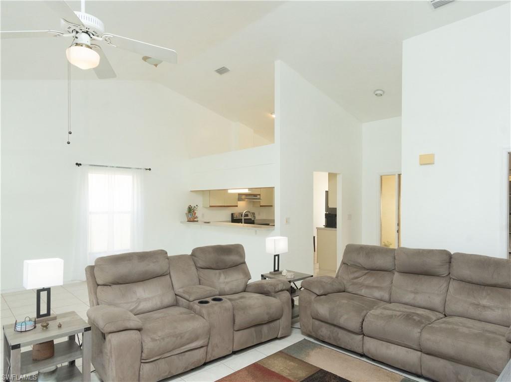 1404 Monarch Circle Naples, FL 34116 - Photo 13 of 33 a living room with furniture and a lamp