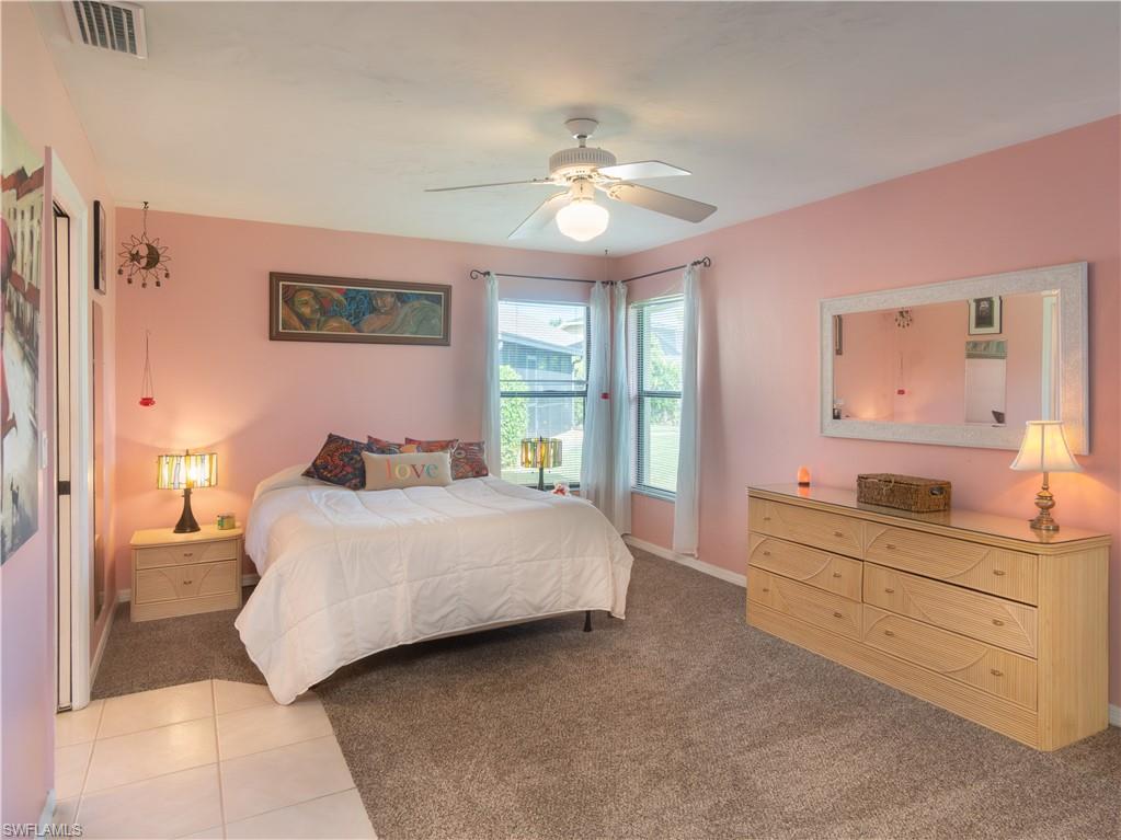 1404 Monarch Circle Naples, FL 34116 - Photo 19 of 33 a bedroom with a large bed and a chandelier