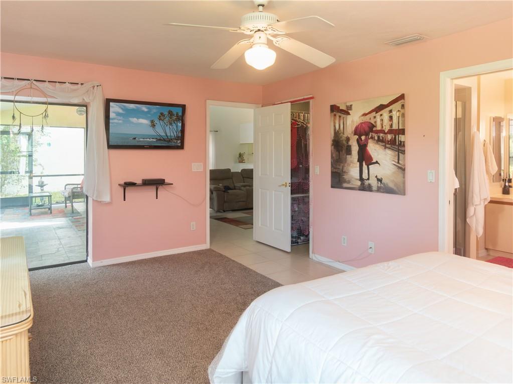 1404 Monarch Circle Naples, FL 34116 - Photo 20 of 33 a bedroom with a bed and a chandelier