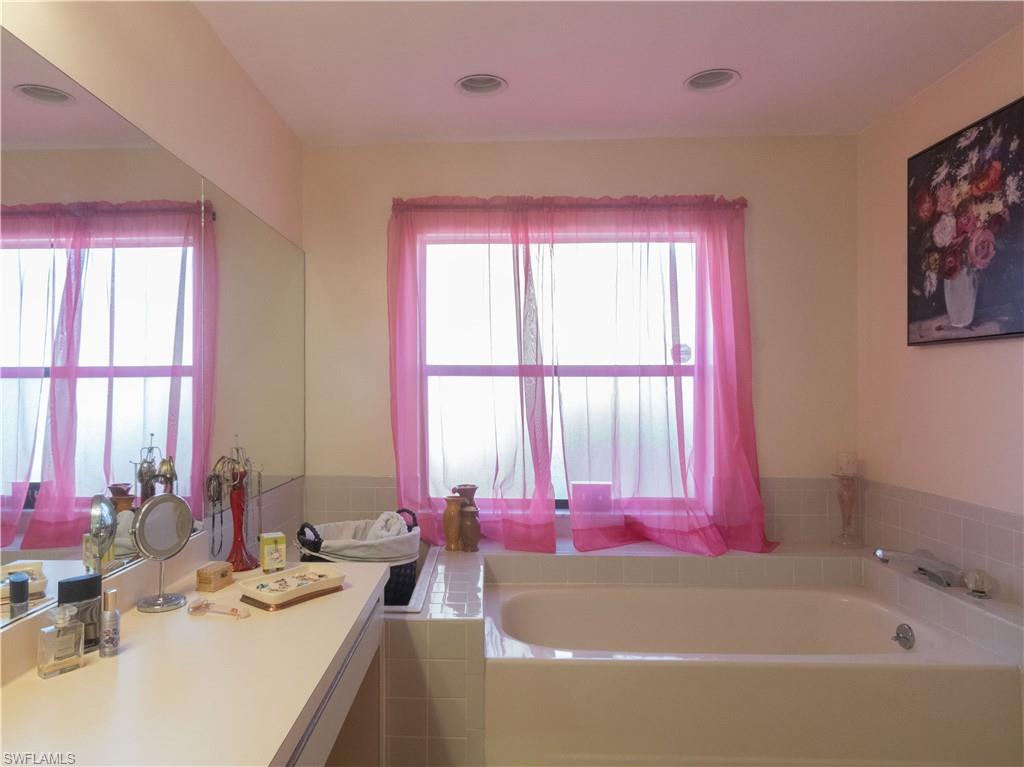 1404 Monarch Circle Naples, FL 34116 - Photo 22 of 33 a white bath tub sitting next to a bathroom sink