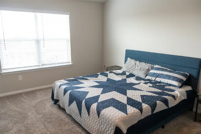a bed sitting in a bedroom next to a window