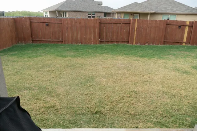a view of backyard with tub and wooden fence