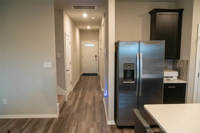 a kitchen with a refrigerator and wooden floor