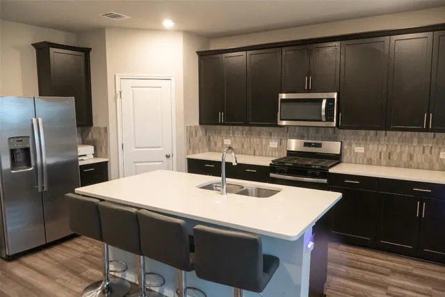 a kitchen with a sink a stove a microwave and refrigerator