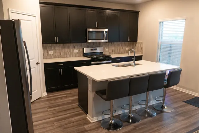 a kitchen with stainless steel appliances wooden cabinets sink and stove