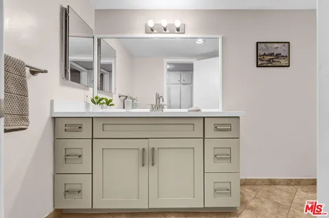 a bathroom with a sink vanity and mirror