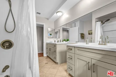 a spacious bathroom with a double vanity sink mirror and shower