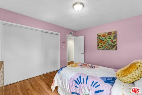a bedroom with a bed and a painting on the wall
