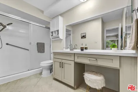 a spacious bathroom with a sink toilet a mirror and shower