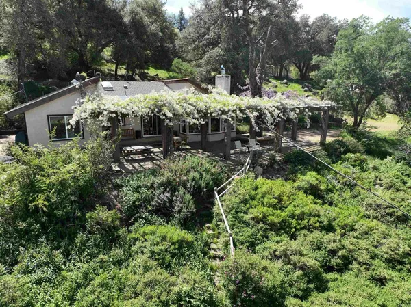 an aerial view of a house with yard and outdoor seating
