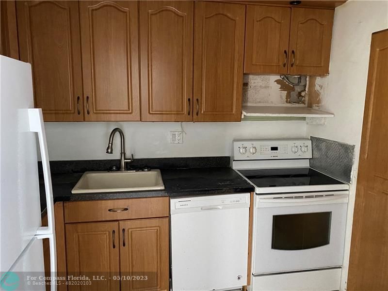 8020 Fairview Drive, Unit 101 Tamarac, FL 33321 - Photo 7 of 15 a kitchen with granite countertop cabinets stainless steel appliances and sink