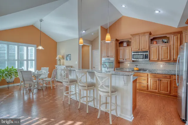 a kitchen with stainless steel appliances granite countertop a refrigerator and a stove top oven