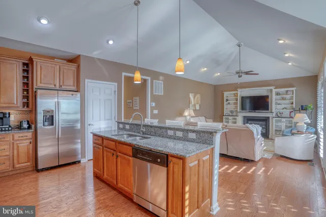 a dining hall with stainless steel appliances granite countertop a stove and a sink