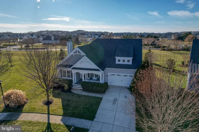 an aerial view of a house with a garden and lake view