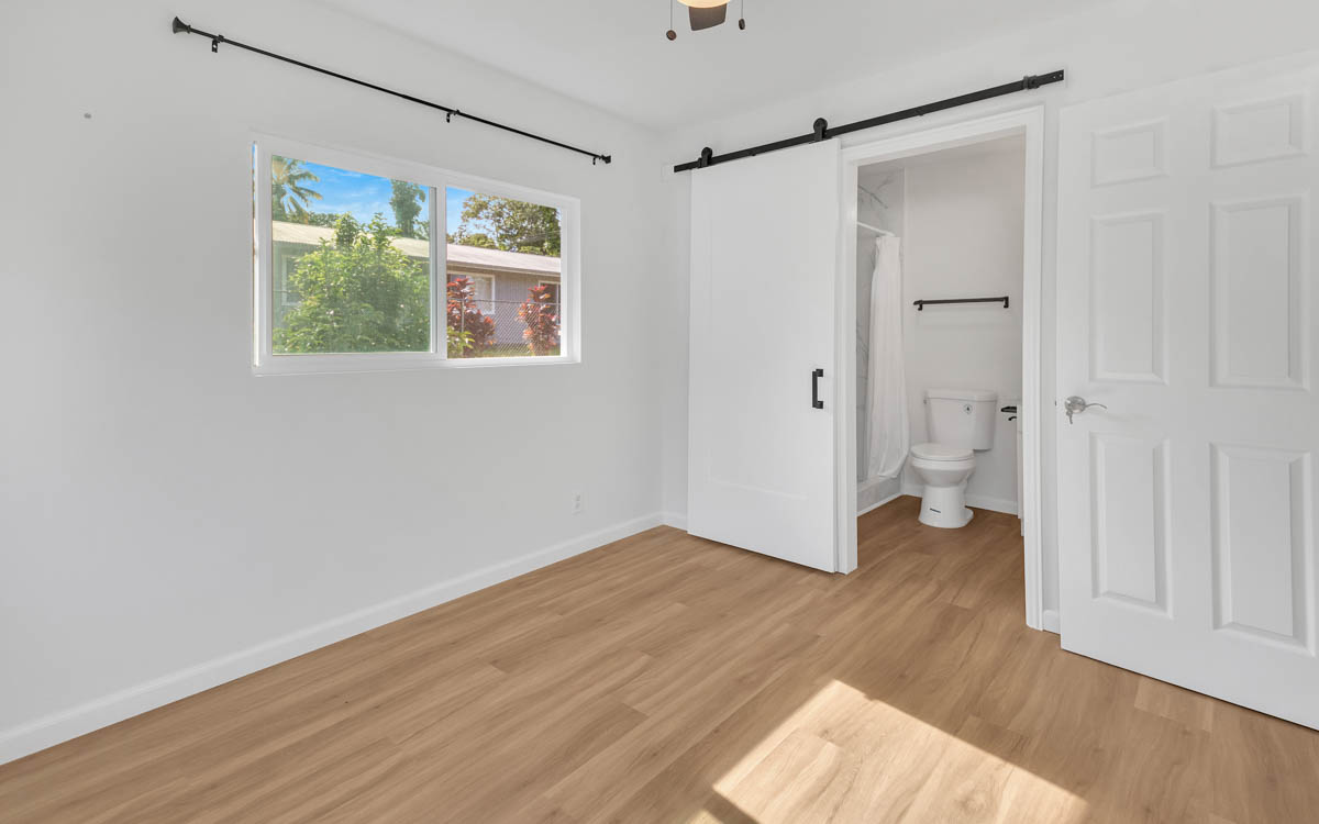 15-385 Puni Makai Loop North Pahoa, HI 96778 - Photo 14 of 22 an empty room with wooden floor and windows