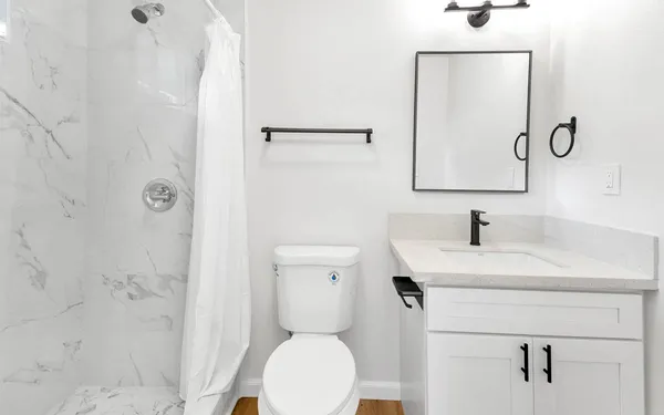 a bathroom with a toilet sink vanity and mirror