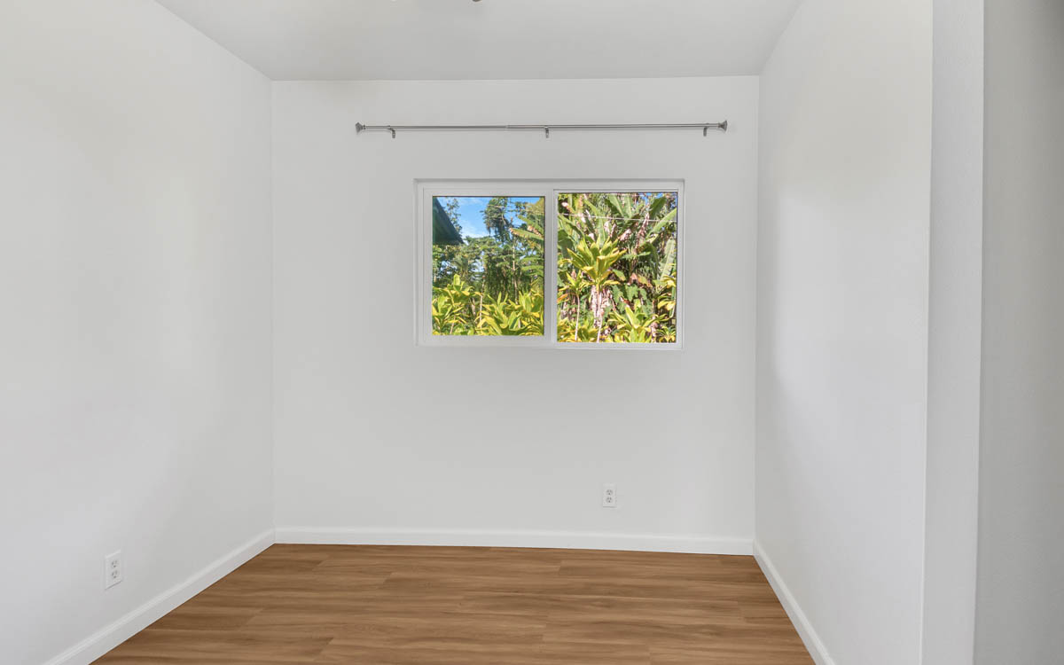 15-385 Puni Makai Loop North Pahoa, HI 96778 - Photo 21 of 22 a view of an empty room with wooden floor and a window