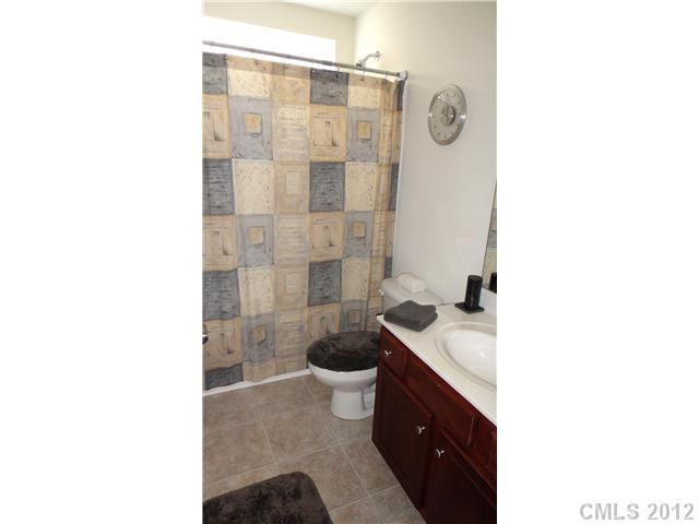 3343 Streamside Drive Davidson, NC 28036 - Photo 14 of 16 a bathroom with a granite countertop sink a toilet a mirror and shower