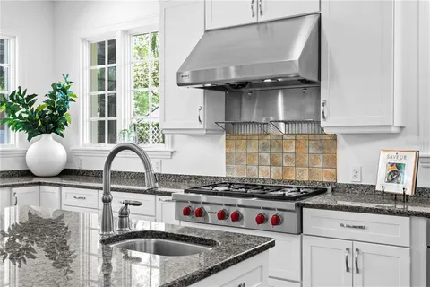 a kitchen with granite countertop a stove a sink and a granite counter tops