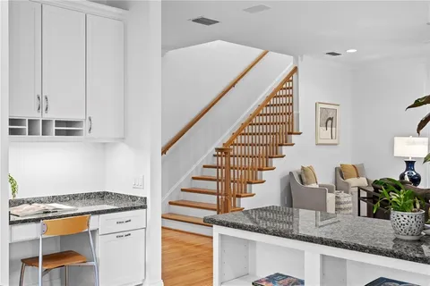 a kitchen with granite countertop a stove a sink dishwasher and cabinets with wooden floor
