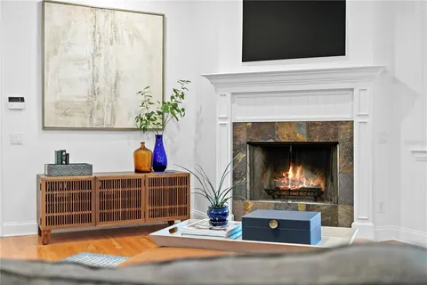 a living room with furniture a fireplace and a flat screen tv