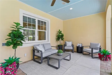 a dining room with furniture and a floor to ceiling window