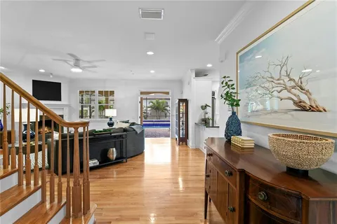 a living room with furniture appliances and wooden floor