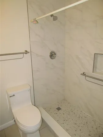 a white toilet sitting next to a bath tub and shower