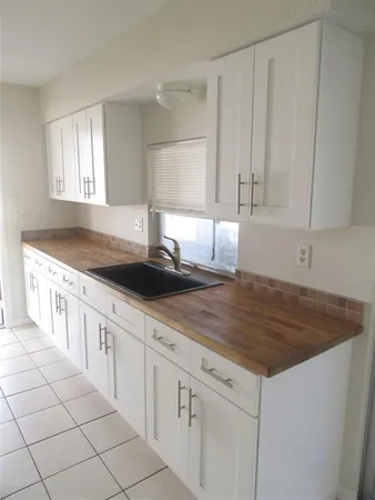 a kitchen with granite countertop white cabinets and sink