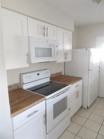 a kitchen with white cabinets and white appliances