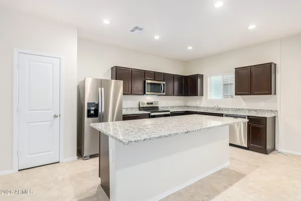 a large kitchen with stainless steel appliances granite countertop a stove a sink and a refrigerator