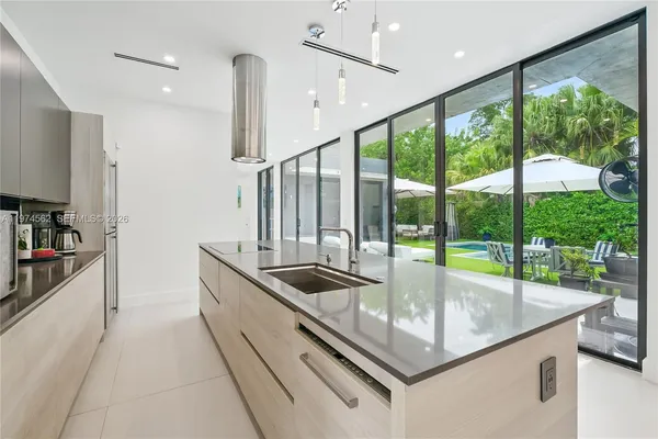 a kitchen with large windows and a sink