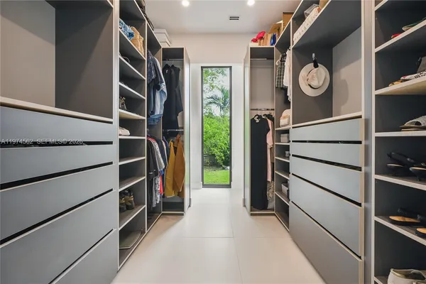 a view of walk in closet with clothes and shoes