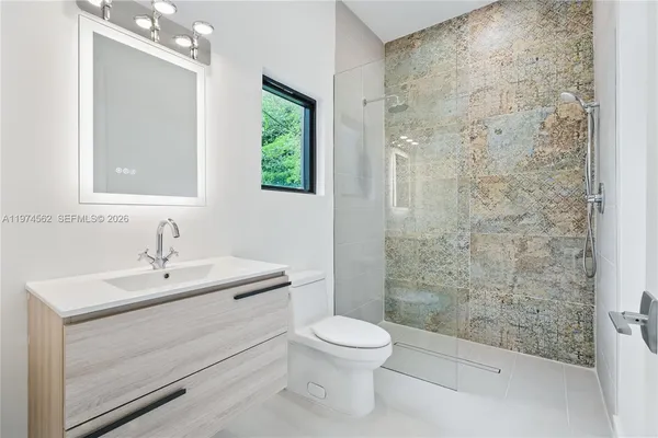 a bathroom with a sink a toilet and shower