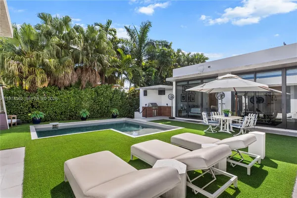 a view of a house with swimming pool and sitting area