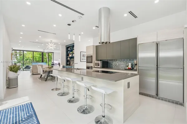 a large kitchen with a large window and stainless steel appliances