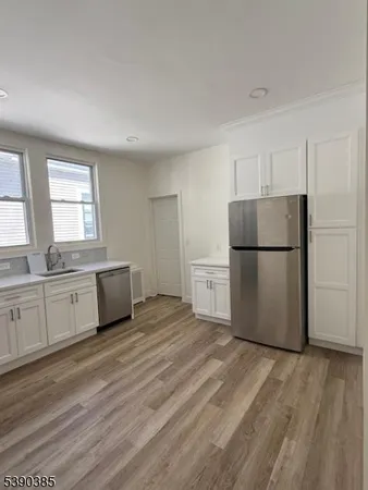a kitchen with a refrigerator sink and cabinets