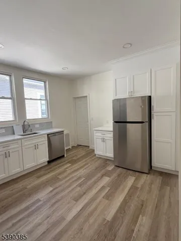 a kitchen with a refrigerator sink and cabinets