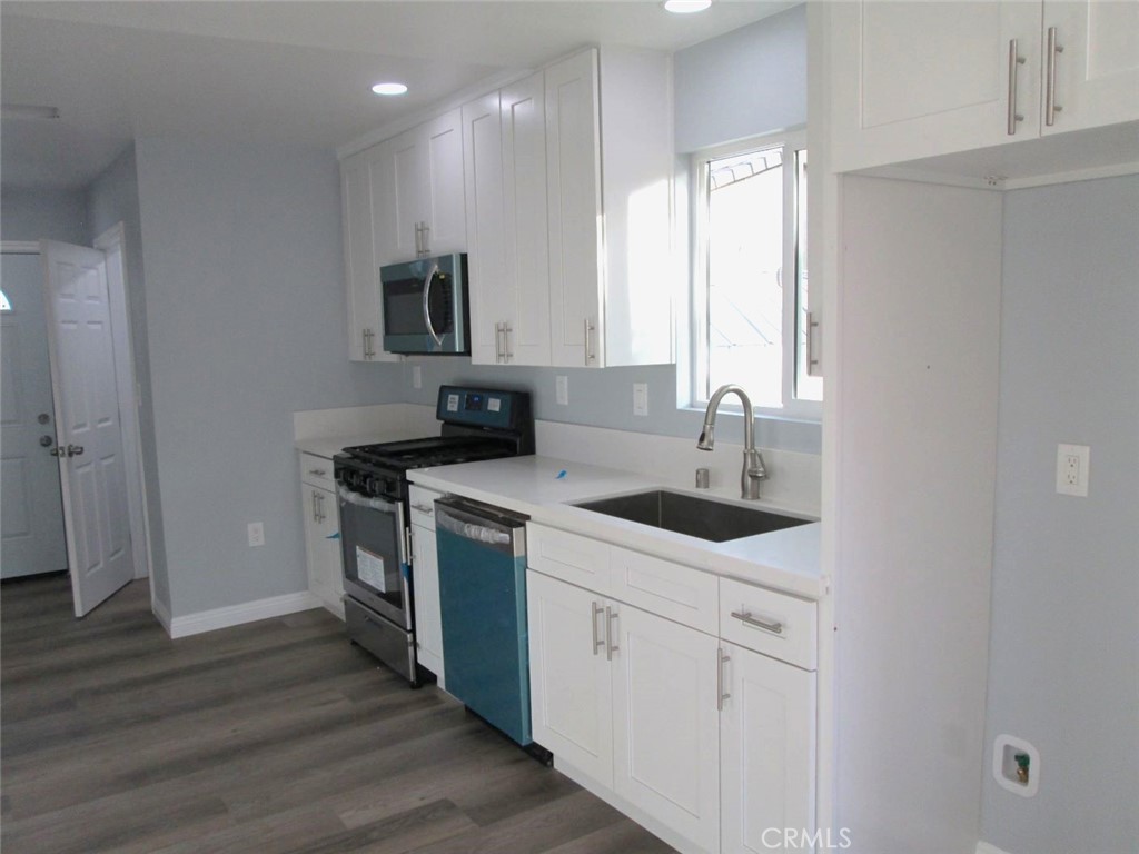 44552 Arabia Street Indio, CA 92201 - Photo 33 of 49 a kitchen with a sink cabinets and wooden floor