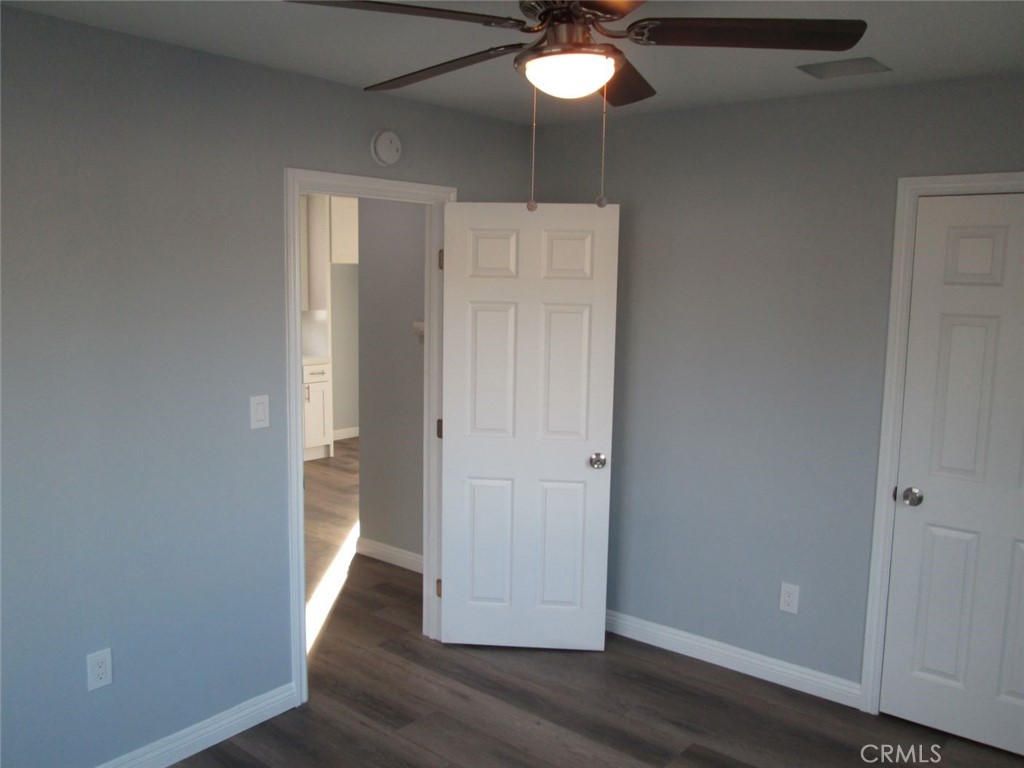 44552 Arabia Street Indio, CA 92201 - Photo 40 of 49 an empty room with wooden floor and chandelier fan