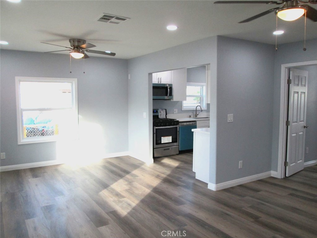 44552 Arabia Street Indio, CA 92201 - Photo 4 of 49 a view of a kitchen with wooden floor and a ceiling fan