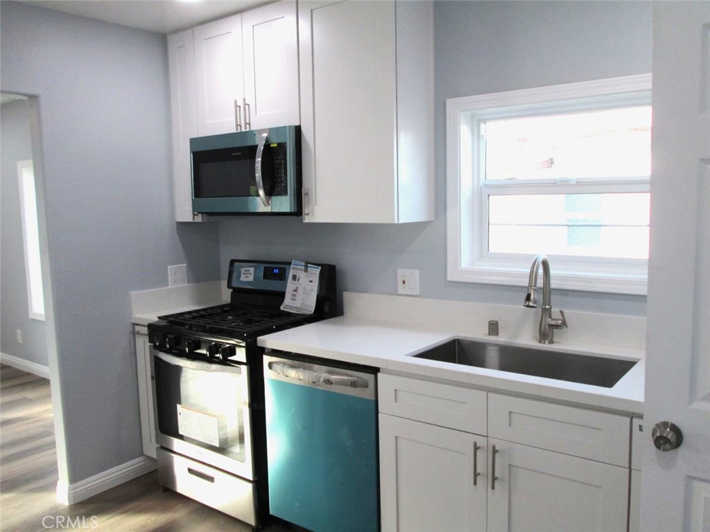 44552 Arabia Street Indio, CA 92201 - Photo 7 of 49 a kitchen with stainless steel appliances granite countertop a sink a stove and a microwave